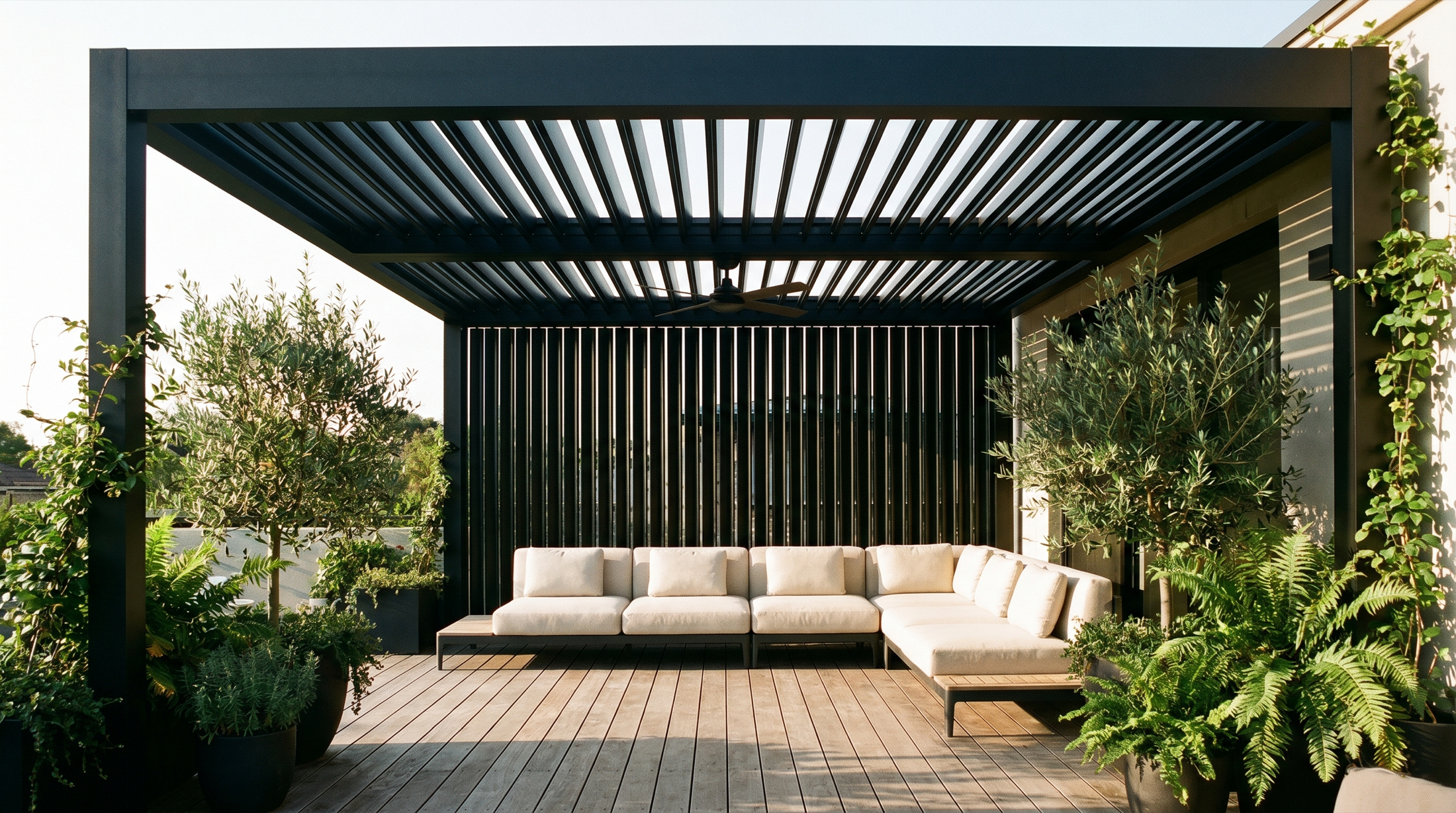 A modern black aluminum louvered pergola over a stylish deck, louvers casting linear shadows.